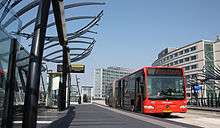 Red articulated bus at a station