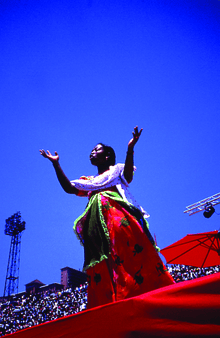 woman singing in red, green and white dress