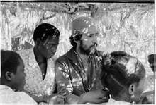Light skinned Latin American doctor with scrub cap in Guinea Bassau amongst four black skinned natives.